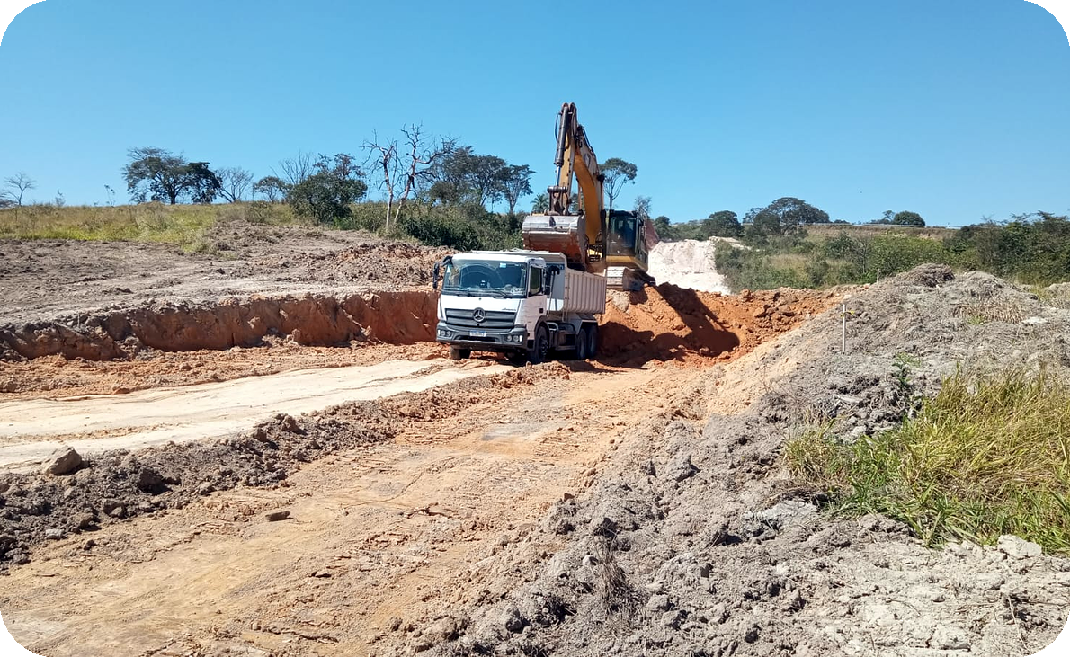 Escavadeira carregando caminhão nas obras do Alta Vista